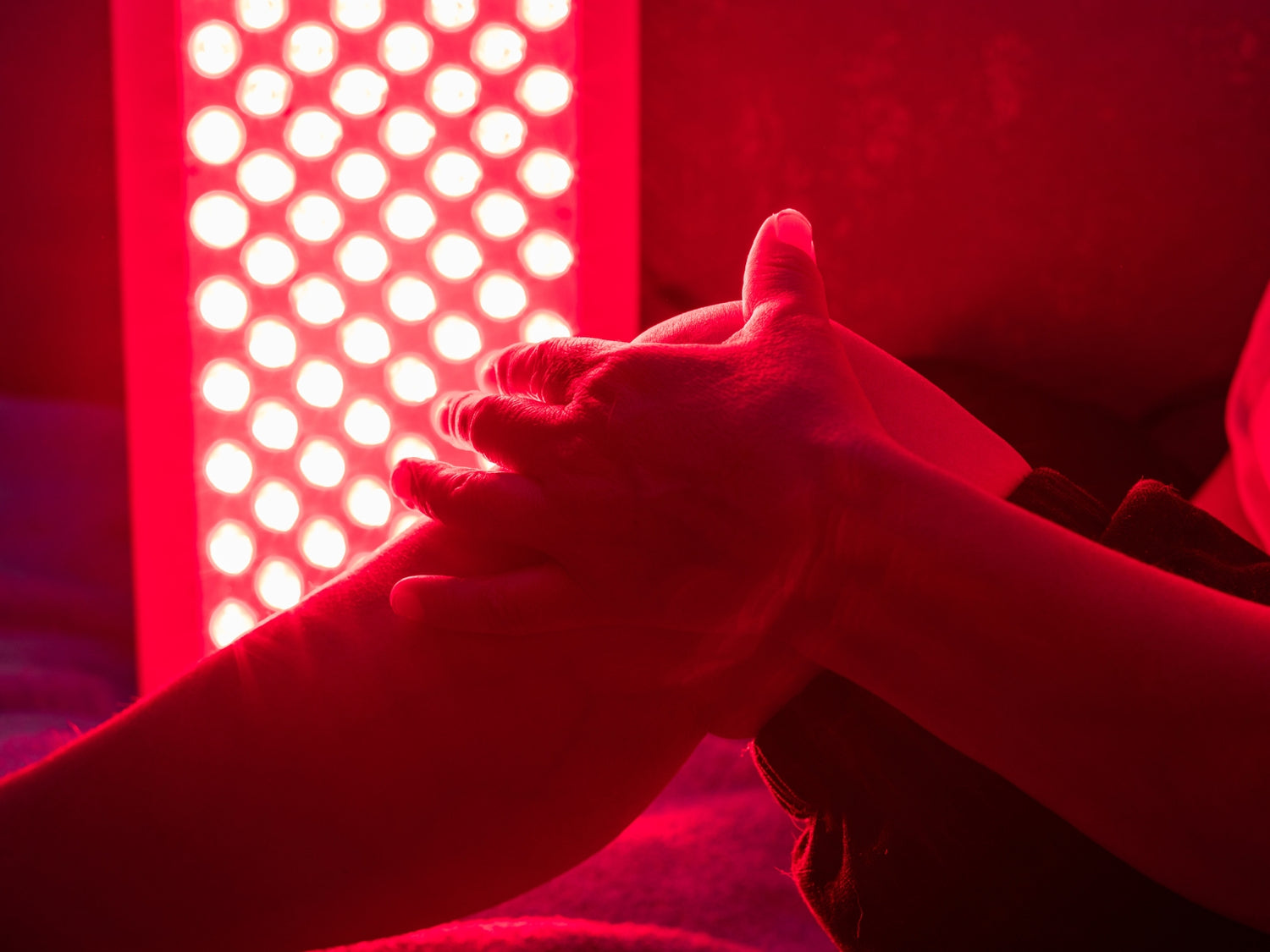 Red light therapy device with hand under the light