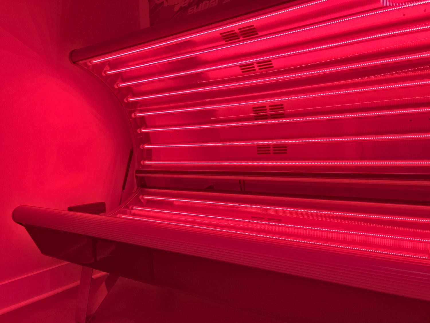Red light therapy bed with glowing red light interior