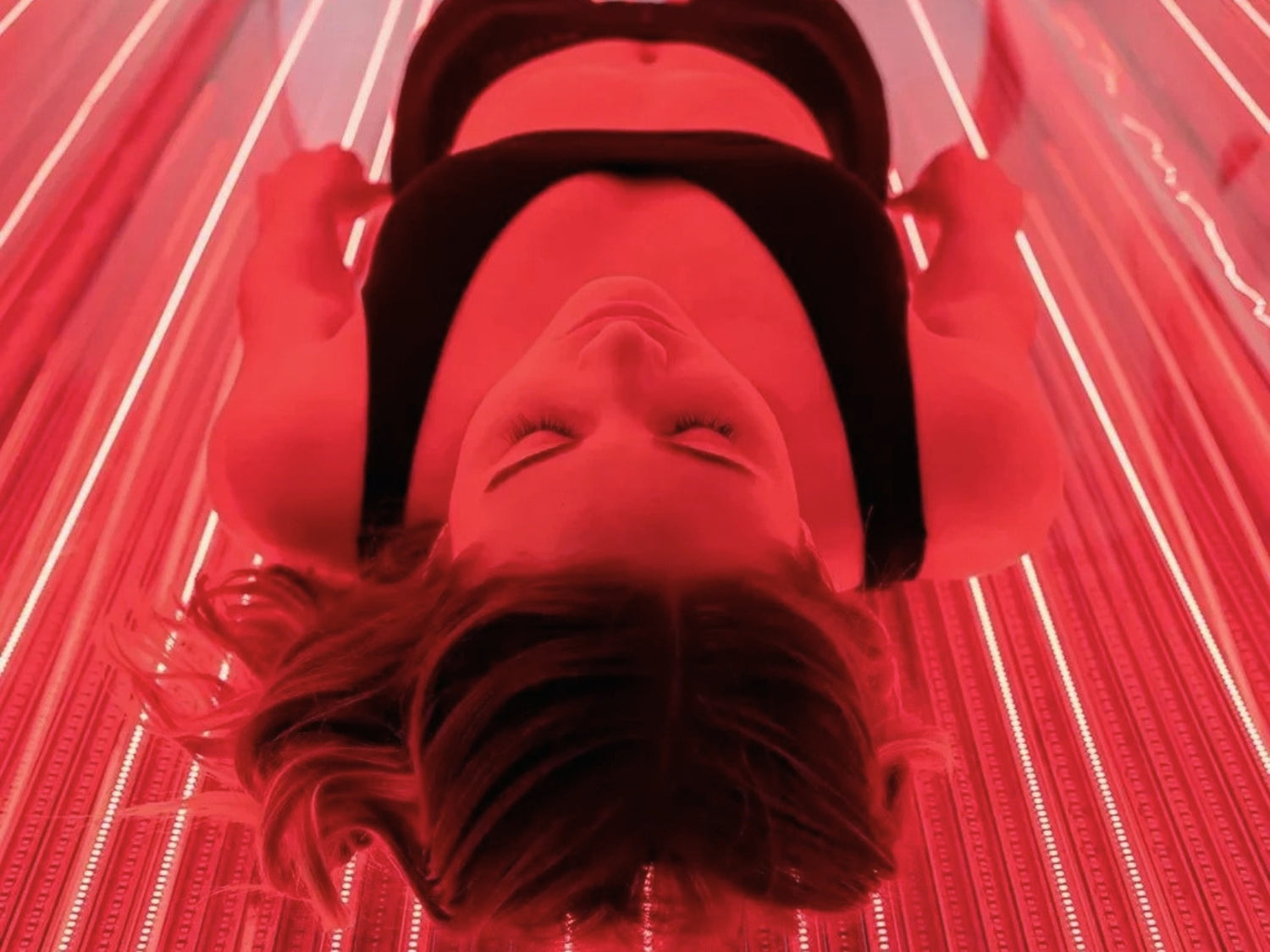 Person lying down, relaxing during a Red Light Therapy Session