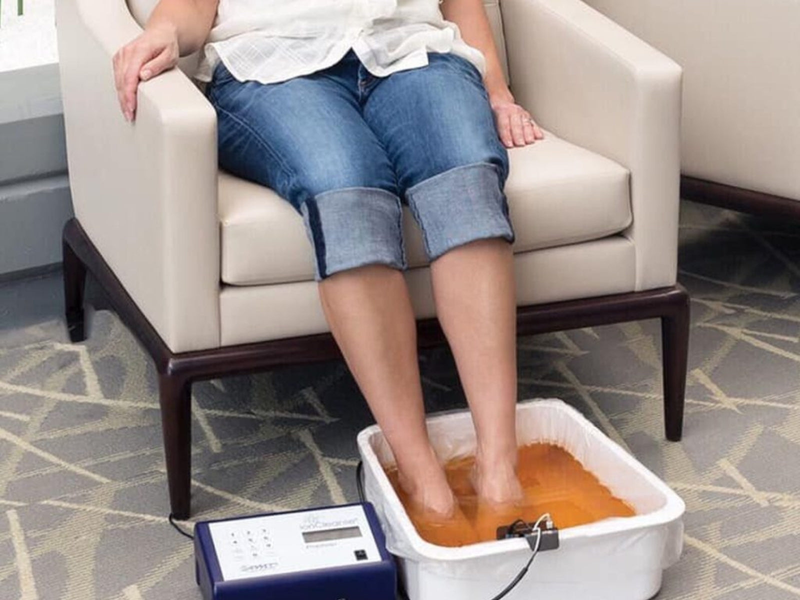 Person sitting in a chair with feet in an foot bath at Synergy Nutrition and Wellness in Western New York.